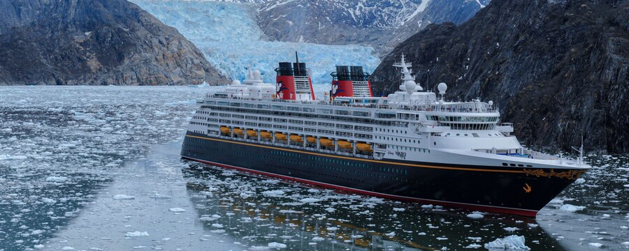 A Disney cruise ship in the water surrounded by glaciers